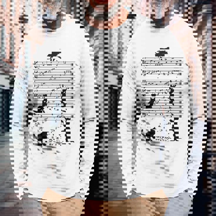 音楽譜上の遊ぶ猫のシルエットデザイン ピアノ音符 遊び心のある猫 猫 ジョーク かわいい 動物好き ギャグ好き 長袖Tシャツ 高齢者への贈り物