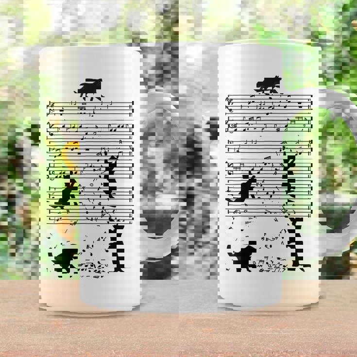 音楽譜上の遊ぶ猫のシルエットデザイン ピアノ音符 遊び心のある猫 猫 ジョーク かわいい 動物好き ギャグ好き コーヒーマグ ギフトのアイデア