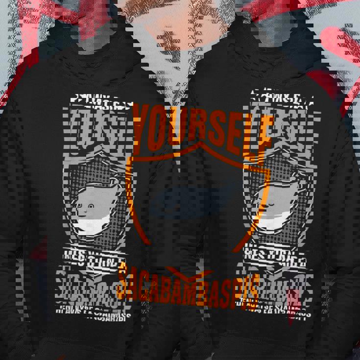 サカバンバスピスのフィッシュミームになれない限り、常に自分らしくありなさい パーカー 面白い贈り物