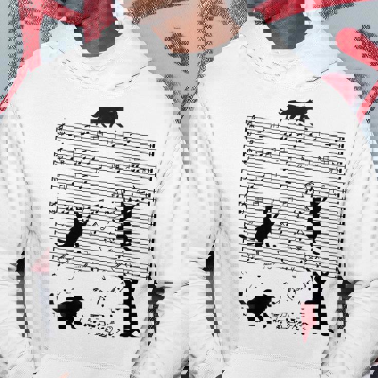 音楽譜上の遊ぶ猫のシルエットデザイン ピアノ音符 遊び心のある猫 猫 ジョーク かわいい 動物好き ギャグ好き パーカー 面白い贈り物