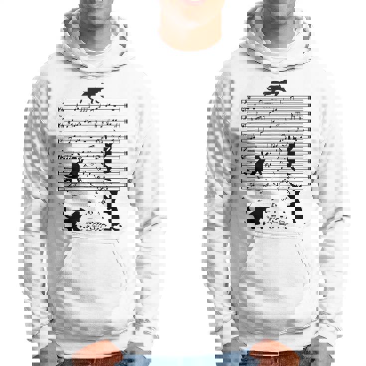 音楽譜上の遊ぶ猫のシルエットデザイン ピアノ音符 遊び心のある猫 猫 ジョーク かわいい 動物好き ギャグ好き パーカー