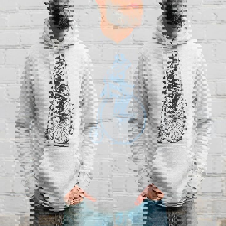 ビンテージのペニーファージング自転車に乗る粋なカエルのサイクリスト パーカー 彼への贈り物