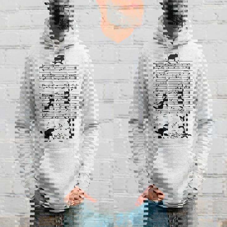 音楽譜上の遊ぶ猫のシルエットデザイン ピアノ音符 遊び心のある猫 猫 ジョーク かわいい 動物好き ギャグ好き パーカー 彼への贈り物