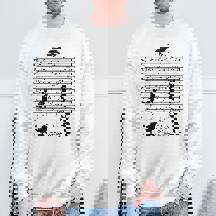 音楽譜上の遊ぶ猫のシルエットデザイン ピアノ音符 遊び心のある猫 猫 ジョーク かわいい 動物好き ギャグ好き スウェットシャツ 高齢者への贈り物