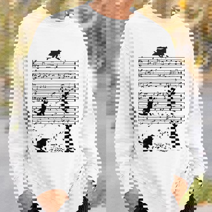 音楽譜上の遊ぶ猫のシルエットデザイン ピアノ音符 遊び心のある猫 猫 ジョーク かわいい 動物好き ギャグ好き スウェットシャツ 彼への贈り物