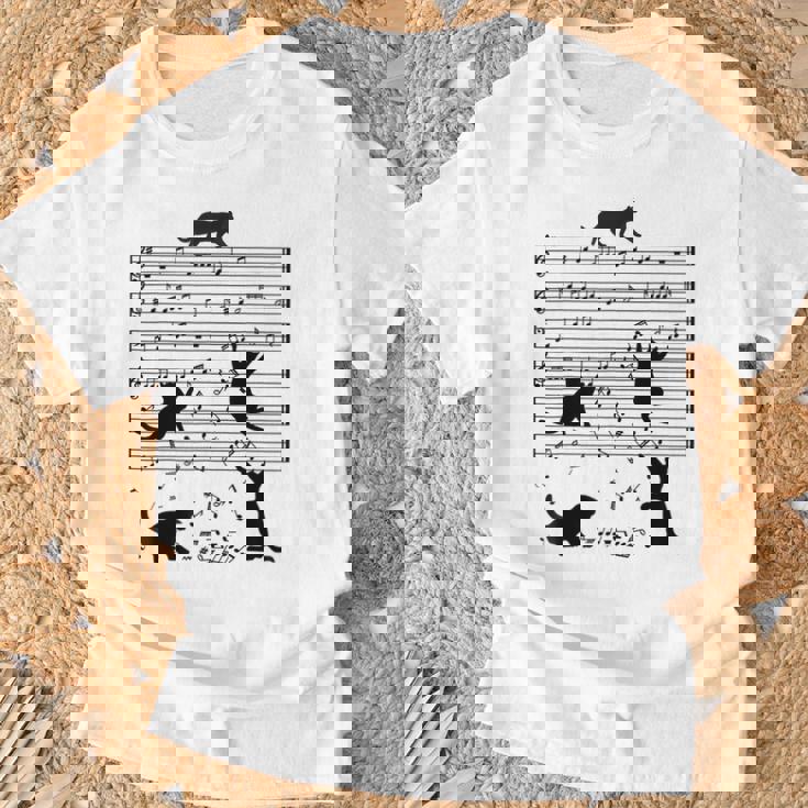音楽譜上の遊ぶ猫のシルエットデザイン ピアノ音符 遊び心のある猫 猫 ジョーク かわいい 動物好き ギャグ好き Tシャツ 高齢者への贈り物