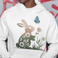 蝶のイースターとデイジーを保持している甘いウサギのウサギ 長袖tシャツ パーカー 面白い贈り物